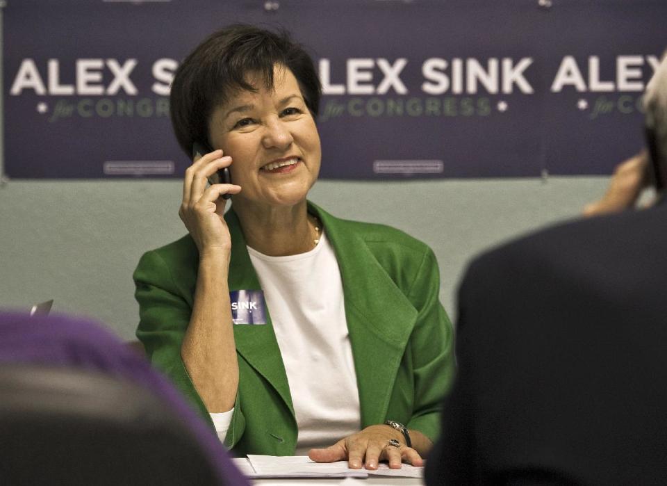 FILE - In this Nov. 23, 2013 file photo, Florida Democratic Congressional candidate Alex Sink works the phone in Clearwater, Fla. Need proof outside money is going to matter in this year’s elections? Just look at spending this week. Republicans are sending almost $2 million into a Florida special election for the U.S. House and Democrats are standing by with almost the same amount. (AP Photo/Steve Nesius, File)