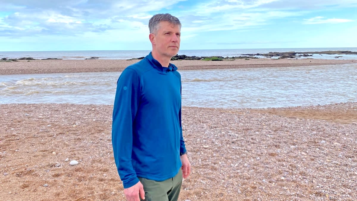  Man on beach wearing Smartwool Men's Active Mesh Hoodie. 