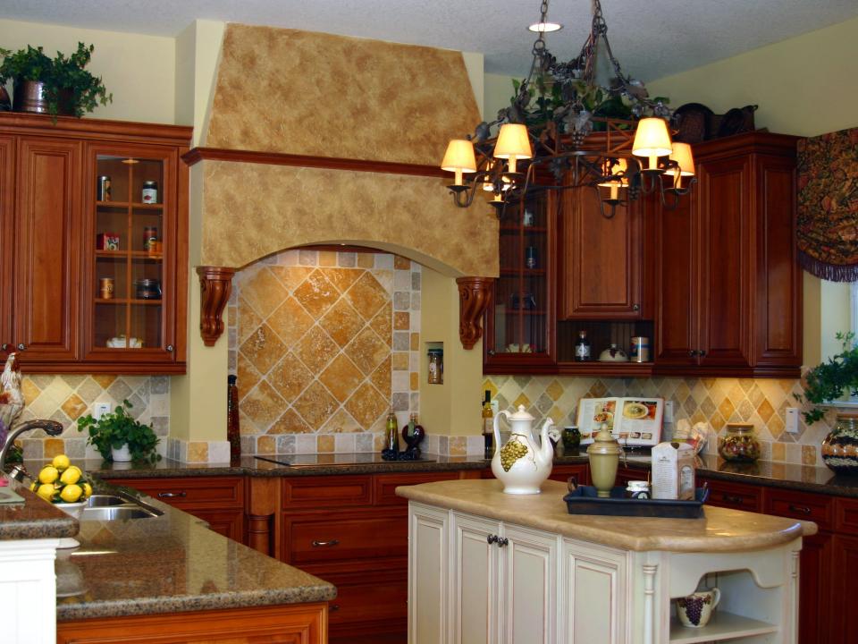 A Tuscan-style kitchen with wooden cabinets, a stone stove backsplash, and iron black chandelier