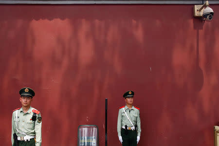 Paramilitary police officers stand underneath a security camera near Beijing's Tiananmen Square, China May 19, 2017. REUTERS/Thomas Peter