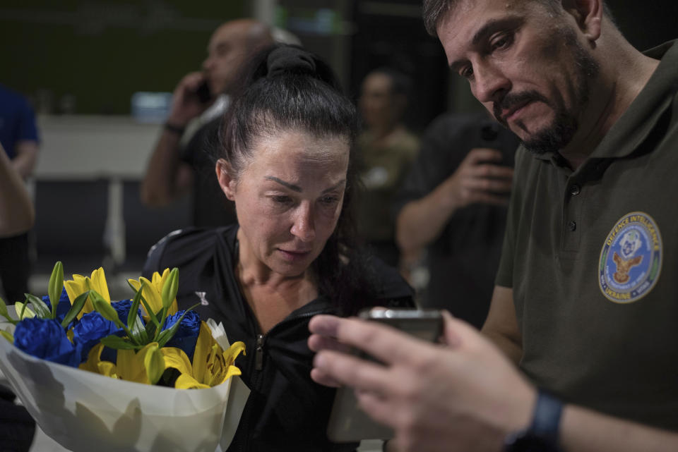 Olena Pekh, left, researcher at Horlivka Art Museum talks to her daughter via videosignal in Kyiv airport, Ukraine, Saturday, June 29, 2024. Ten Ukrainians who had been held prisoners for years, were released from Russian captivity on Friday with a mediation of Vatican, said Ukraine's President Volodymyr Zelenskyy. (AP Photo/Alex Babenko)