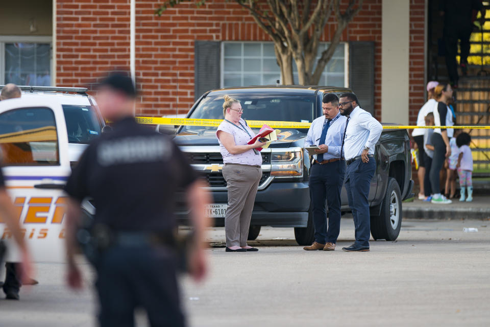 Law enforcement officials investigate a scene where, according to Harris County Sheriff Ed Gonzalez, three juveniles were found living alone along with the skeletal remains of another person, possibly a juvenile, in a third floor apartment at the CityParc II at West Oaks Apartments on Sunday, Oct. 24, 2021, at in west Houston. (Mark Mulligan/Houston Chronicle via AP)