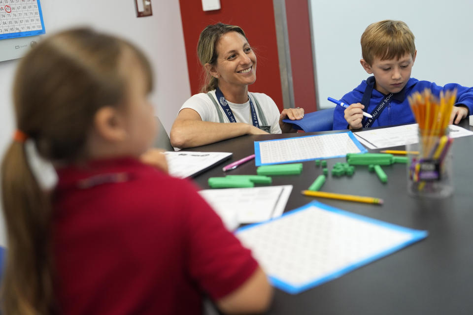 Math interventionist Jessica Foreman, center, works with a small group of first graders, at A.D. Henderson School in Boca Raton, Fla., Tuesday, April 16, 2024. When teachers at the K-8 public school, one of the top-performing schools in Florida, are asked how they succeed, one answer is universal: They have autonomy. (AP Photo/Rebecca Blackwell)