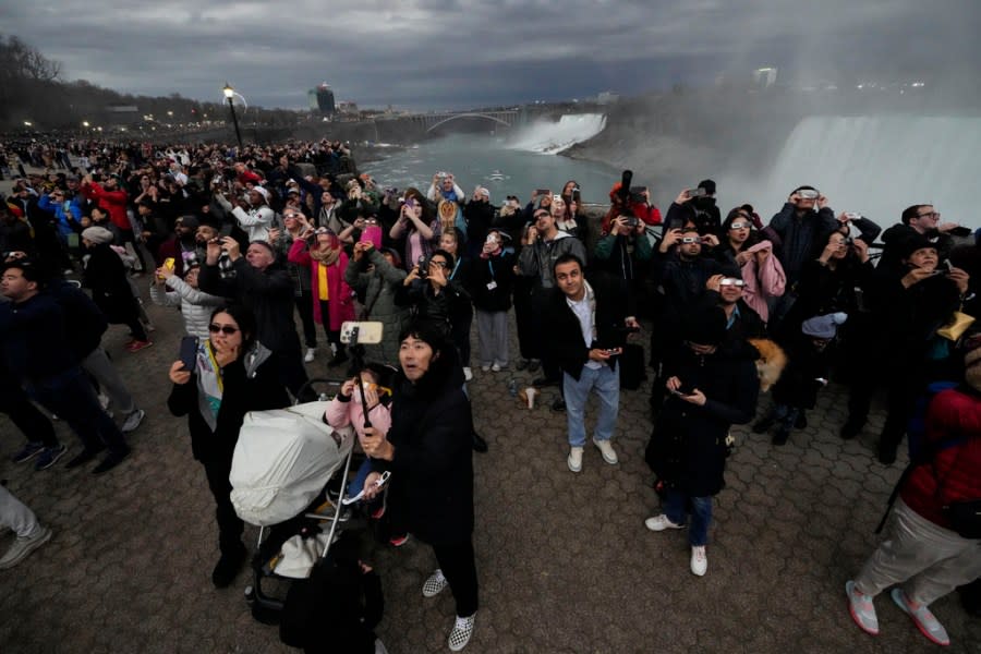 People gather to watch the total solar eclipse from Niagara Falls, Ontario, Monday, April 8, 2024. (AP Photo/Matt Rourke)