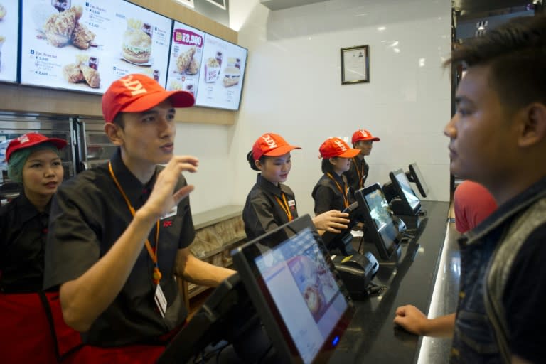 KFC staff serving customers at the US food giant's first branch in Yangon on June 30, 2015