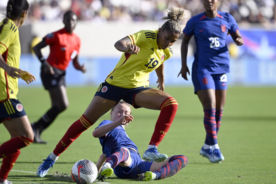 United States defender Emily Sonnett, bottom, slides in to tackle the ball away from Colombia defender Jorelyn Carabalí (19) during the second half of an international friendly soccer match Sunday, Oct. 29, 2023, in San Diego. (AP Photo/Alex Gallardo)