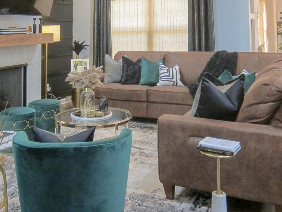 The living room sports an accent wall and a color scheme based on emerald green and chocolate brown.