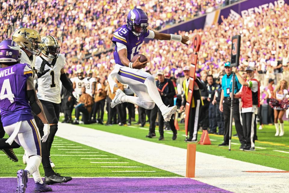 Nov 12, 2023; Minneapolis, Minnesota, USA; Minnesota Vikings quarterback Joshua Dobbs (15) scores on a touchdown run as New Orleans Saints cornerback Alontae Taylor (1) look on during the second quarter at U.S. Bank Stadium. Mandatory Credit: Jeffrey Becker-USA TODAY Sports