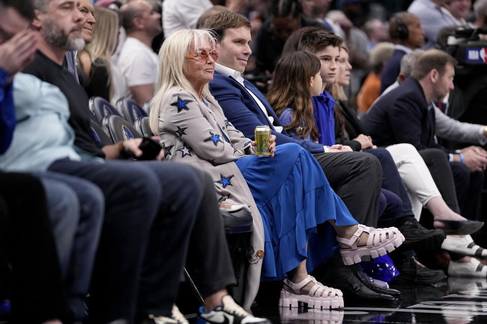 Miriam Adelson, center left, controlling shareholder of the Las Vegas Sandals Corp., and Dallas Mavericks Governor Patrick Dumont, center right, watch the Phoenix Suns play the Dallas Mavericks in the first half of an NBA basketball game in Dallas, Thursday, Feb. 22, 2024. (AP Photo/Tony Gutierrez)