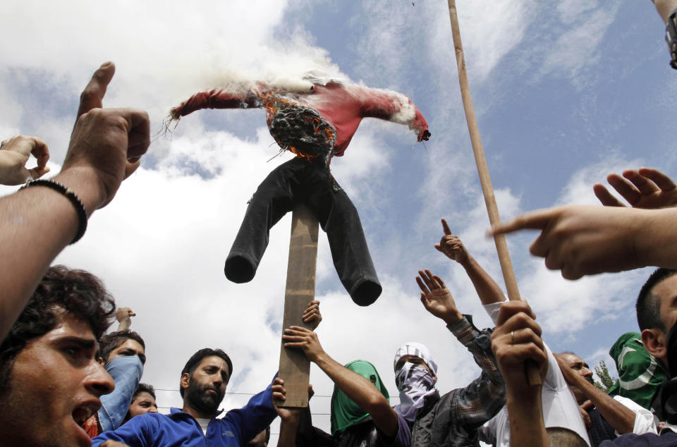 Kashmiri Muslim protesters burn an effigy representing the United States as they shout slogans during a protest in Srinagar, India, Tuesday, Sept. 18, 2012. The protest was held against an anti-Islam film called "Innocence of Muslims" that ridicules Islam's Prophet Muhammad. (AP Photo/Mukhtar Khan)