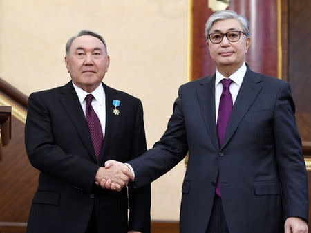 Acting President of Kazakhstan Kassym-Jomart Tokayev (R) shakes hands with his predecessor Nursultan Nazarbayev during a joint session of the houses of parliament in Astana, Kazakhstan March 20, 2019. Kazakh Presidential Press Service/Handout via REUTERS ATTENTION EDITORS - THIS IMAGE WAS PROVIDED BY A THIRD PARTY.