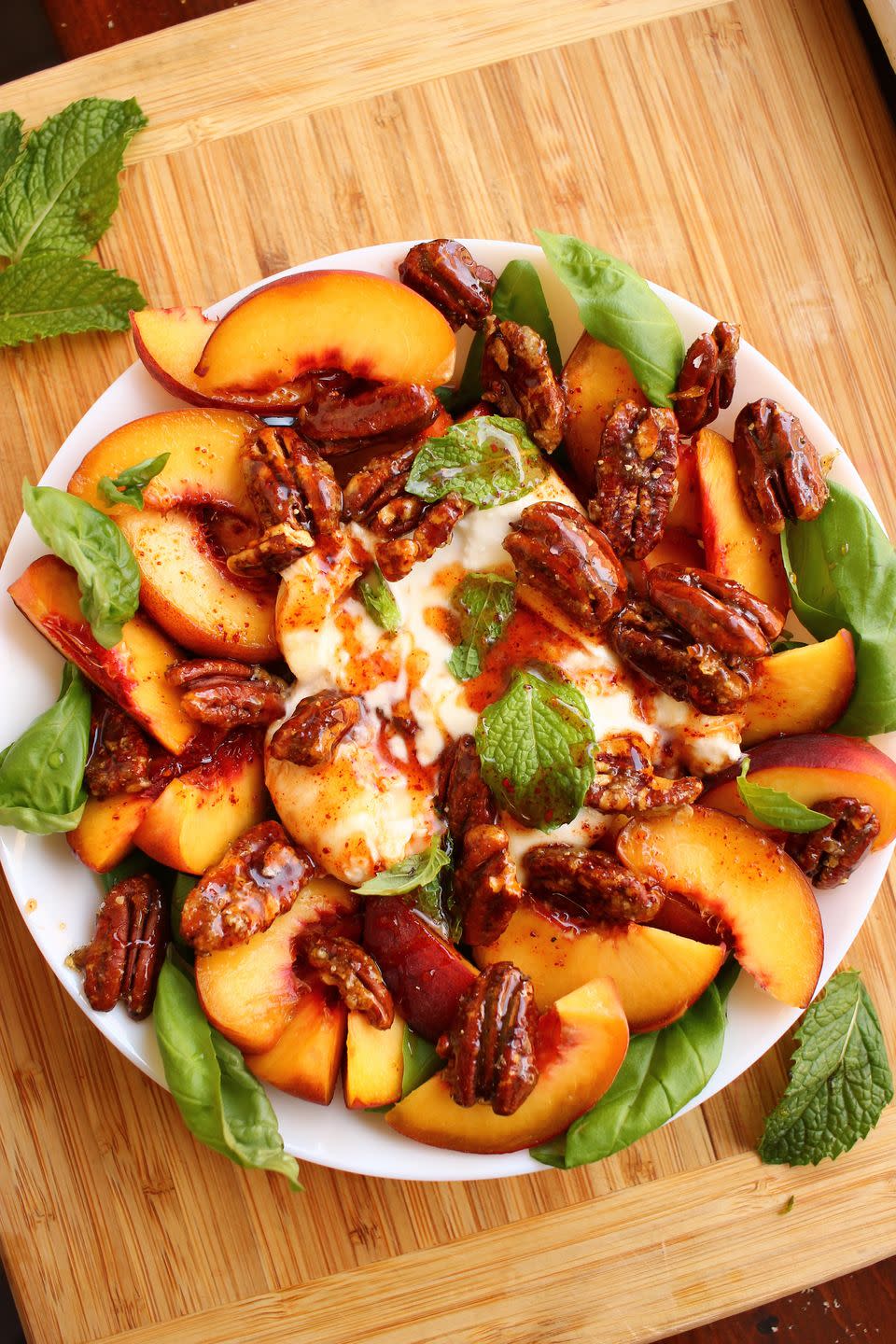 <p>We changed up the <a href="https://www.delish.com/cooking/recipe-ideas/a19695744/easy-caprese-salad-recipe/" rel="nofollow noopener" target="_blank" data-ylk="slk:classic Caprese salad;elm:context_link;itc:0" class="link ">classic Caprese salad</a> by switching out juicy tomatoes for plump summer peaches and replacing sliced fresh mozzarella with its creamier cousin, burrata. Surrounded by fragrant basil then topped with <a href="https://www.delish.com/cooking/recipe-ideas/a34099585/candied-pecans-recipe/" rel="nofollow noopener" target="_blank" data-ylk="slk:candied pecans;elm:context_link;itc:0" class="link ">candied pecans</a> and a drizzle of spicy honey, this sweet & savory salad is a STUNNER.</p><p>Get the <strong><a href="https://www.delish.com/cooking/recipe-ideas/a33472464/peach-and-burrata-caprese-recipe/" rel="nofollow noopener" target="_blank" data-ylk="slk:Peach & Burrata Caprese recipe;elm:context_link;itc:0" class="link ">Peach & Burrata Caprese recipe</a></strong>.</p>
