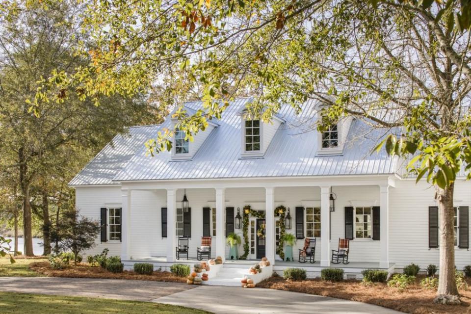 <p>There's no need to go over the top with your outdoor Halloween decorations just because the neighbors did. Here, stately, elegant array of pumpkins spruces up the outside of this home beautifully. Meanwhile, a simple green garland decorates the front door. </p>