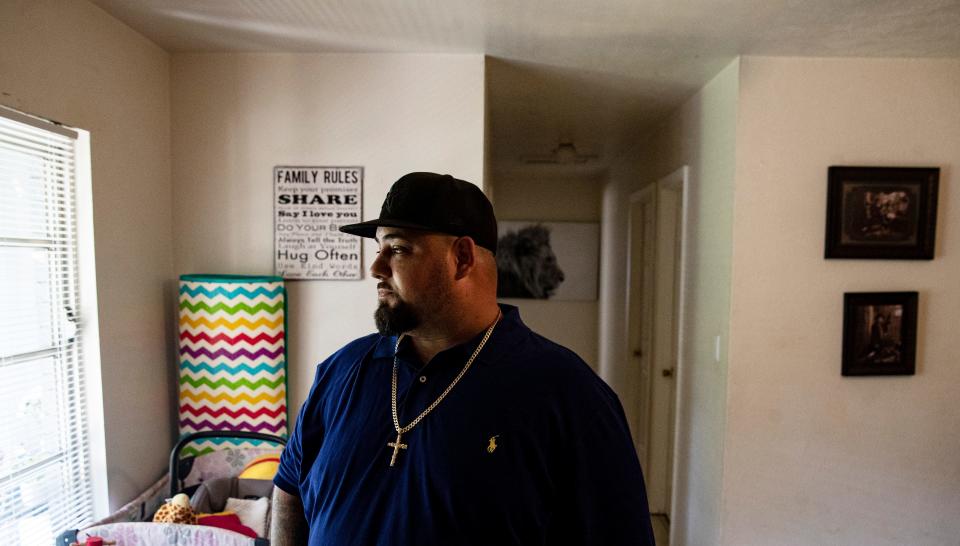 Ariel Maldonado, 38, stands for a portrait in his North Fort Myers home on Sunday, August 14, 2022. He says fines and fees associated with his felony conviction have deeply affected his life. He wants to be able to get insurance, 401k and other benefits so he can build a future for himself and his family, but being an ex-felon prevents that.
