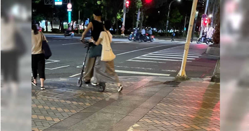 黃宣與女友滑板車不但溜上馬路，也在人行道上來去自如。（圖／讀者提供）