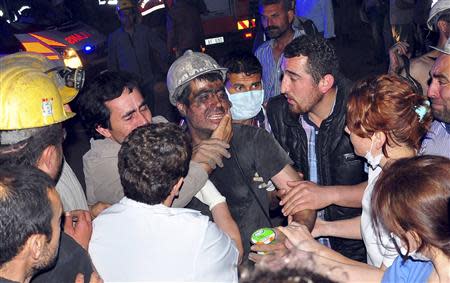 A rescued miner surrounded by relatives, medics and other miners cries after being rescued from a coal mine he was in trapped in Soma, a district in Turkey's western province of Manisa May 13, 2014. REUTERS/Ihlas/Yilmaz Saripinar