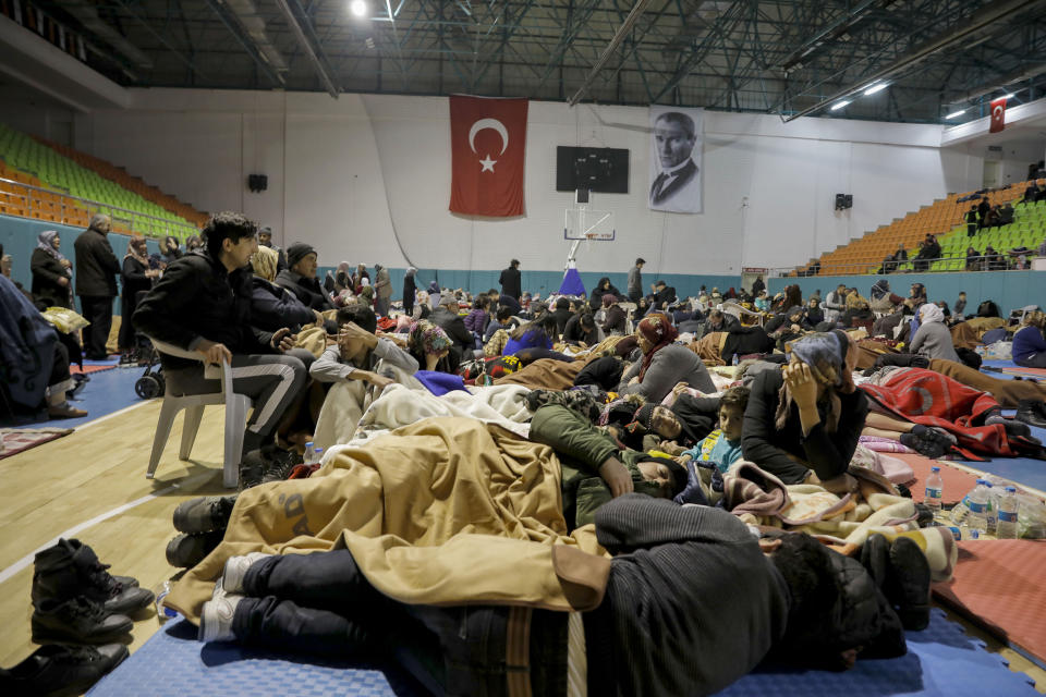 People gather inside a sports hall to spend the night following Friday's earthquake that destroyed their houses, in Elazig, eastern Turkey, late Saturday, Jan. 25, 2020. More than 24 hours after a powerful earthquake hit eastern Turkey rescuers continued to pull survivors from under collapsed buildings Sunday. (Ugur Can/DHA via AP)