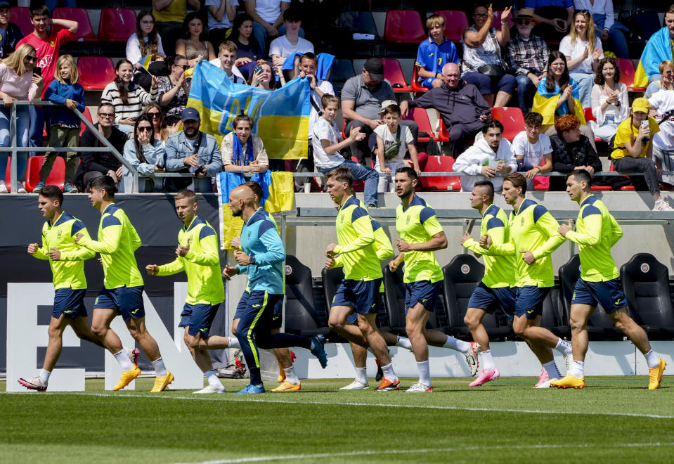 Players of Ukraine's national soccer team warm up during a public training session in Wiesbaden, Germany, Thursday, June 13, 2024, ahead of their group E match against Romania at the Euro 2024 soccer tournament. (AP Photo/Michael Probst)