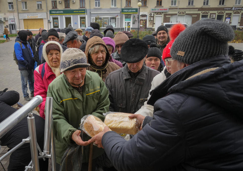 Local residents stand in line waiting for free bread from volunteers in Bakhmut, the site of the heaviest battle against the Russian troops in the Donetsk region, Ukraine, Friday, Oct. 28, 2022. (AP Photo/Efrem Lukatsky)