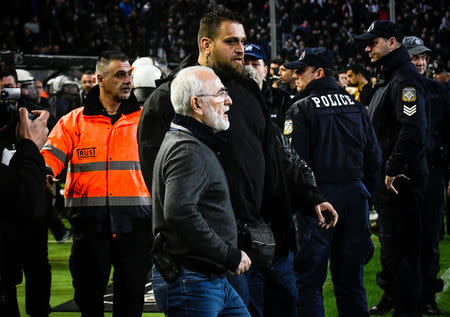 Russian-born Greek businessman and owner of PAOK Salonika, Ivan Savvides (C), pictured with what appears to be a gun in a holster, enters the pitch after the referee annulled a goal of PAOK during their soccer match against AEK Athens in Toumba Stadium in Thessaloniki, Greece, March 11, 2018. Antonis Nicolopoulos/Eurokinissi via REUTERS