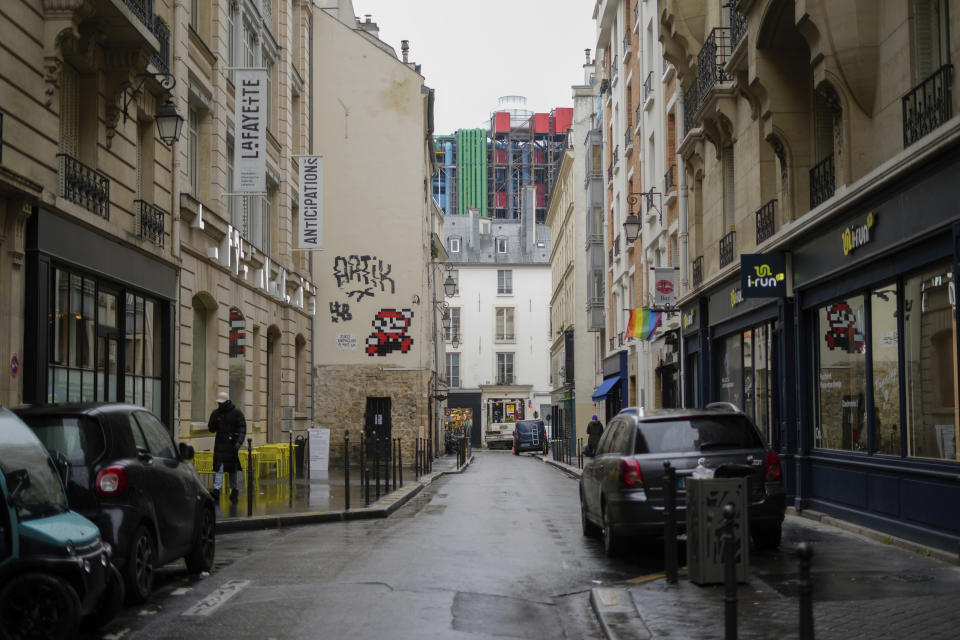 A mosaic by French artist Invader, left, is seen on a street of Paris, Thursday, Feb. 29, 2024. For the Paris Olympics, it could almost have been a new sport: Score points by scouring France's capital for mosaics that a mystery artist who calls himself "Invader" has cemented to walls across the city, across the world and even had carried aloft to the International Space Station. (AP Photo/Thibault Camus)