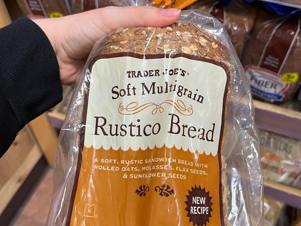 hand holding up a bag of rustico bread at trader joes