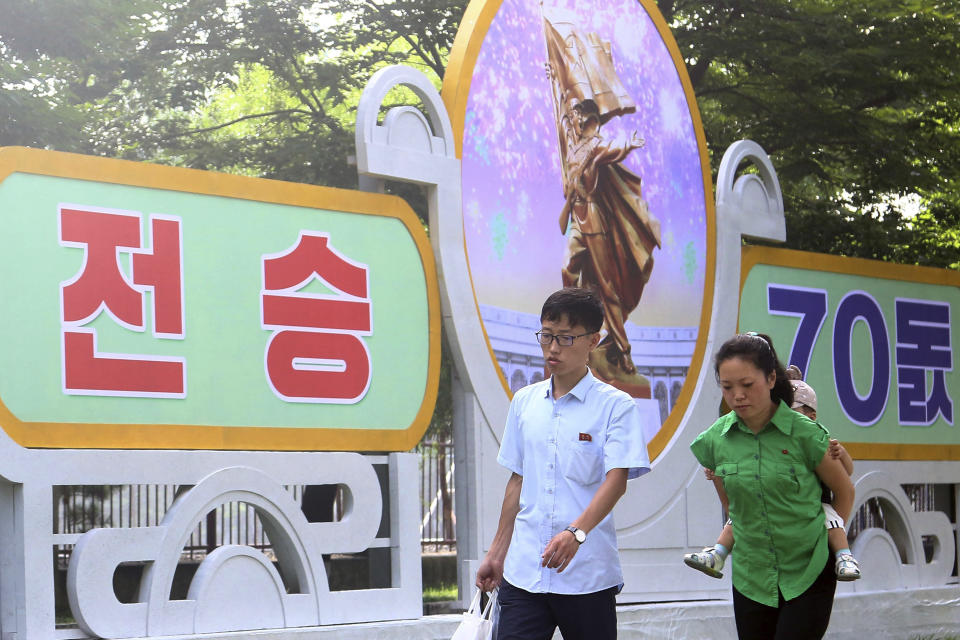 Citizens walk on a street of Pothonggang District of Pyongyang, North Korea Thursday, July 27, 2023, on the 70th anniversary of an armistice that halted fighting in the 1950-53 Korean War. A banner, left, reads "Win every battle." (AP Photo/Cha Song Ho)