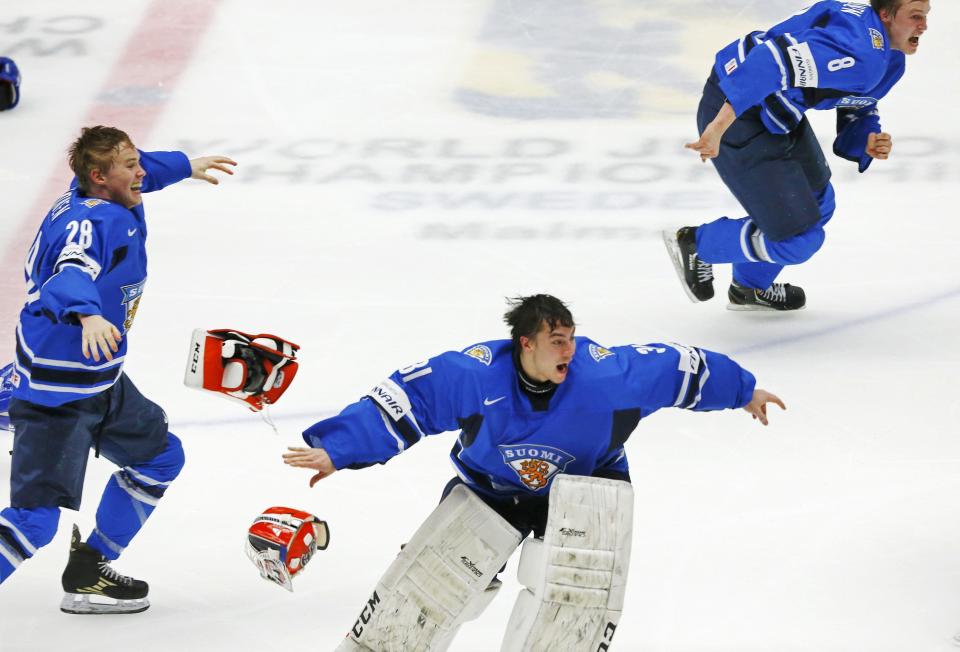 Finland's goalie Juuse Saros (C), Artturi Lehkonen (L) and Saku Maenlanen celebrate after defeating Sweden in overtime of their IIHF World Junior Championship gold medal ice hockey game in Malmo, Sweden, January 5, 2014. REUTERS/Alexander Demianchuk (SWEDEN - Tags: SPORT ICE HOCKEY)