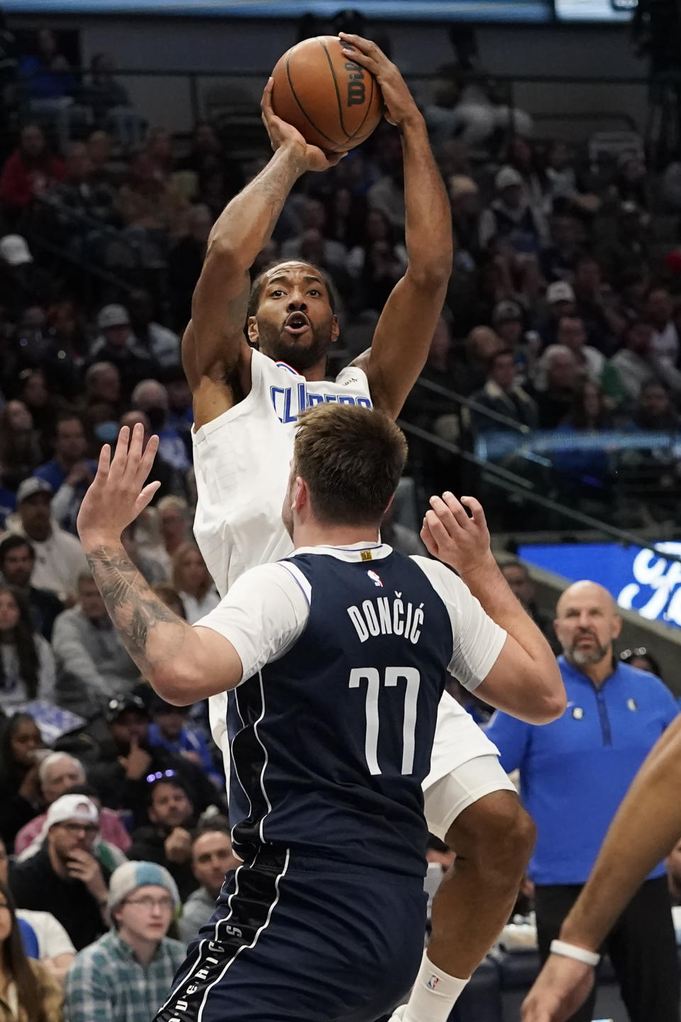 Los Angeles Clippers forward Kawhi Leonard shoots against Dallas Mavericks guard Luka Doncic (77) during the first half of an NBA basketball game in Dallas, Sunday, Jan. 22, 2023. (AP Photo/LM Otero)