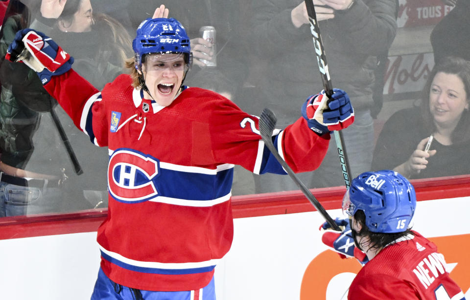 Montreal Canadiens' Kaiden Guhle (21) celebrates with teammate Alex Newhook (15) after scoring against the Boston Bruins during overtime NHL hockey game action in Montreal, Saturday, Nov. 11, 2023. (Graham Hughes/The Canadian Press via AP)