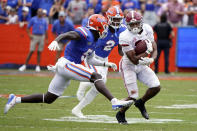 Alabama running back Jase McClellan, right, gains yardage as he tries to get past Florida cornerback Kaiir Elam (5) and linebacker Amari Burney (2) during the first half of an NCAA college football game, Saturday, Sept. 18, 2021, in Gainesville, Fla. (AP Photo/John Raoux)