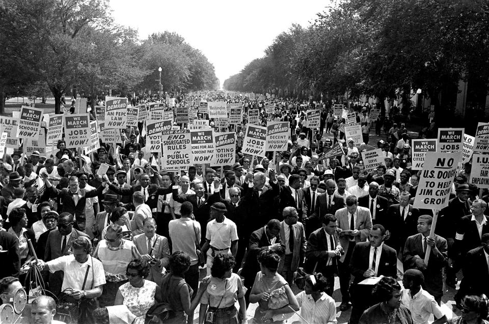 FILE - In this Aug. 28, 1963, file photo Dr. Martin Luther King Jr., center left with arms raised, marches along Constitution Avenue with other civil rights protestors carrying placards, from the Washington Monument to the Lincoln Memorial during the March on Washington. The annual celebration of the Martin Luther King Jr. holiday in his hometown in Atlanta is calling for renewed dedication to nonviolence following a turbulent year. The slain civil rights leader's daughter, the Rev. Bernice King, said in an online church service Monday, Jan. 18, 2021, that physical violence and hateful speech are “out of control” in the aftermath of a divisive election followed by a deadly siege on the U.S. Capitol in Washington by supporters of President Donald Trump. (AP Photo, File)