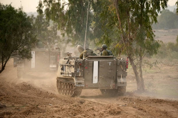 An Israeli armoured vehicle heads towards the Gaza Strip on 22 November 2023 in Southern Israel (Getty Images)
