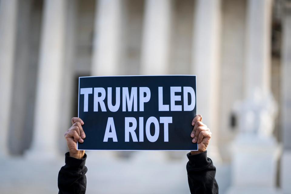 Valarie Walker of New York City raises her sign as protestors gather outside the United States Supreme Court as the court reviews a ruling by a Colorado court that barred former President Donald Trump from appearing on the state’s Republican primary ballot due to his role in the Jan. 6, 2021 attacks on the U.S. Capitol.