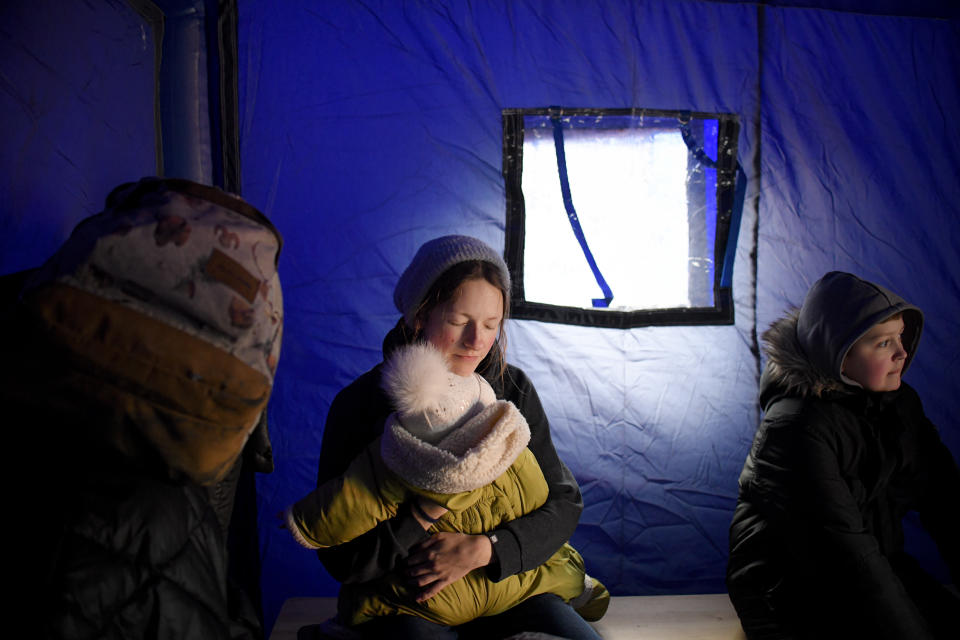 FILE - A refugee fleeing the conflict from neighboring Ukraine holds her baby as she sits in a tent at the Romanian-Ukrainian border, in Siret, Romania, Saturday, Feb. 26, 2022. Since Russia launched its attacks against Ukraine on Feb. 24, more than 6 million people have fled war-torn Ukraine, the United Nations refugee agency announced Thursday, May 12, 2022. (AP Photo/Andreea Alexandru, File)