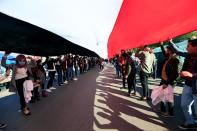 University students carry an Iraqi flag, during ongoing anti-government protests in Baghdad