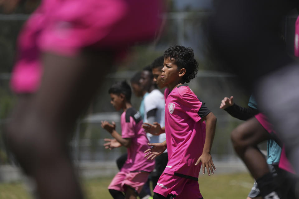 Youths warm up for training at the Independiente del Valle soccer club in Quito, Ecuador, Friday, Sept. 2, 2022. The club trains young men in soccer while providing them with up to a high school graduation and has become a key source for the country’s national soccer team. (AP Photo/Dolores Ochoa)