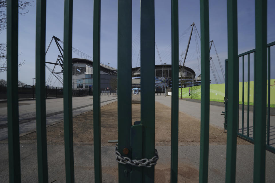 FILE - In this April 9, 2020, file photo, Gates stand locked outside the closed Manchester City Etihad Stadium, in Manchester, northern England, as the English Premier League soccer season has been suspended due to coronavirus. With no games being played, recent sports headlines have centered around hopes and dreams — namely, the uncharted path leagues and teams must navigate to return to competition in the wake of the pandemic. (AP Photo/Jon Super, File)