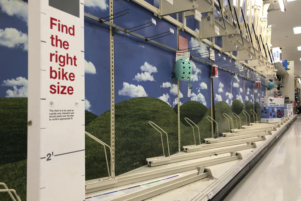 FILE-In this Thursday, June 11, 2020, photo, bicycle display racks are empty at a Target in Milford, Mass. A bicycle rush has been brought on by the coronavirus pandemic. In the U.S., bicycle aisles at mass merchandisers like Walmart and Target have been swept clean, officials say, and independent shops are doing a brisk business and are selling out of low- to mid-range "family" bikes. (AP Photo/Robert F. Bukaty)
