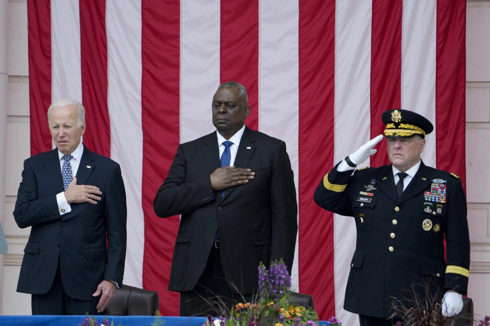 President Joe Biden holds his hand on his heart as he stands with Defense Secretary Lloyd Austin and Chairman of the Joint Chiefs of Staff Gen. Mark Milley during the playing of "Taps," at the Memorial Amphitheater of Arlington National Cemetery in Arlington, Va., on Memorial Day, Monday, May 29, 2023. (AP Photo/Susan Walsh)