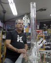 Jay Work talks to a reporter at his Grateful J's smoke shop, Thursday, Jan. 12, 2017, in Margate, Fla. High-end German glass water pipe maker Roor and its American licensee are filing lawsuits against smoke shops and mom-and-pop convenience stores in Florida, California and New York alleging that they are selling Roor counterfeits, violating its trademark. (AP Photo/Alan Diaz)