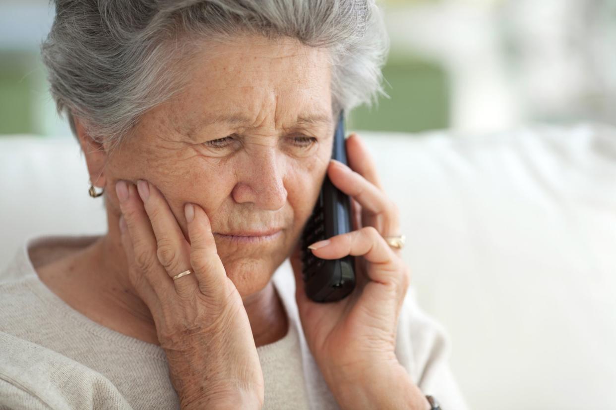 concerned looking senior woman on phone