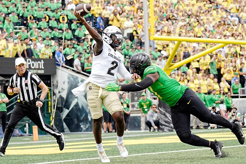 Colorado quarterback Shedeur Sanders (2) throws a pass while under pressure from Oregon linebacker Blake Purchase (17) during the first half at Autzen Stadium.