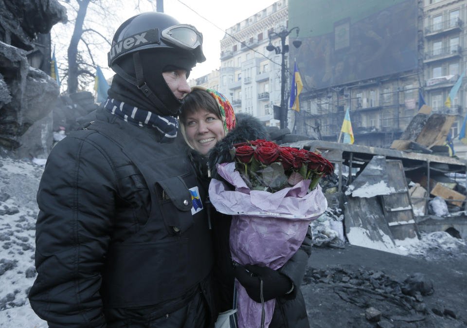 An opposition supporter hugs his future bride after he asked her to marry him at barricades in central Kiev, the epicenter of the country's current unrest, Ukraine, Sunday, Feb. 2, 2014. The supporter took his bride-to-be specially to barricades to share a tender moment there. Kitted out in masks, helmets and protective gear on the arms and legs, radical activists are the wild card of the Ukraine protests now starting their third month, declaring they're ready to resume violence if the stalemate persists. (AP Photo / Efrem Lukatsky)