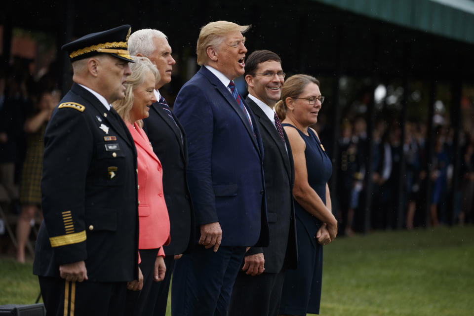 President Donald Trump sings "God Bless America" during an Armed Forces welcome ceremony for the new chairman of the Joint Chiefs of Staff Gen. Mark Milley, Monday, Sept. 30, 2019, at Joint Base Myer-Henderson Hall, Va. From left, Milley, Hollyanne Milley, Vice President Mike Pence, Defense Secretary Mark Esper, and Leah Esper. (AP Photo/Evan Vucci)