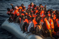 <p>Sub-saharan refugees and migrants on an overcrowded dinghy wait to be rescued by a team of the Spanish NGO Proactiva Open Arms, 24 miles north of Sabratha, Lybia, inside the so called Search and Rescue zone SAR, early in the morning on Tuesday, July 19, 2016. (AP Photo/Santi Palacios) </p>