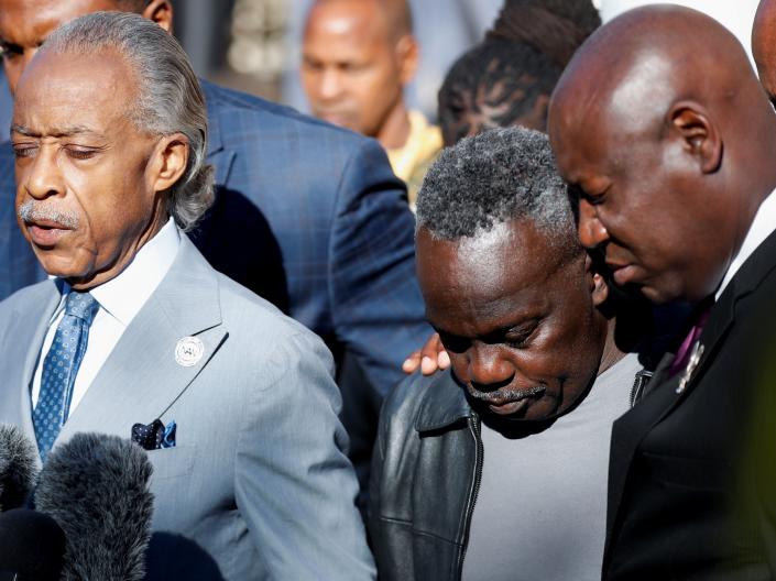 Reverend Al Sharpton, Marcus Arbery, father of Ahmaud Arbery, and attorney Ben Crump, pray outside the Glynn County Courthouse.