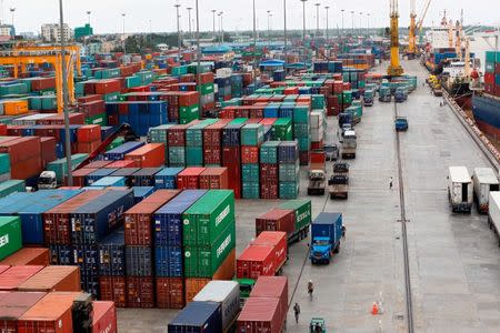 Workers are seen among the containers at Asia World port in Yangon, Myanmar in this file photo from July 2, 2014. REUTERS/Soe Zeya Tun/Files