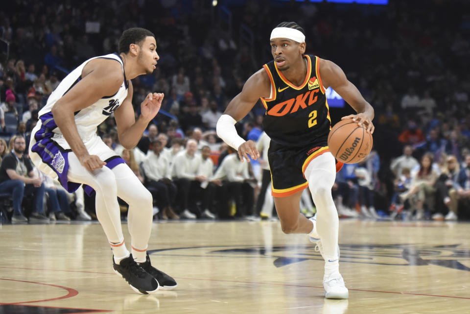 Oklahoma City Thunder guard Shai Gilgeous-Alexander, right, drives past Sacramento Kings forward Keegan Murray, left, in the second half of an NBA basketball game, Sunday, Feb. 11, 2024, in Oklahoma City. (AP Photo/Kyle Phillips)