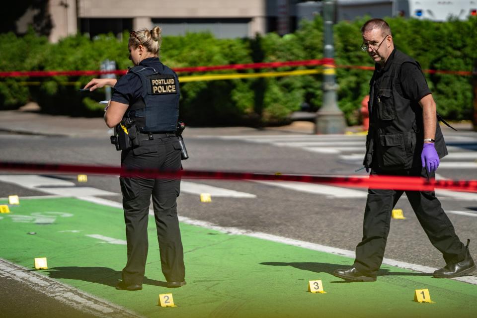 In this July 17, 2021, file photo, police investigate an overnight fatal shooting in Portland, Ore. Portland is on track to shatter its record of 66 homicides, set in 1987. The city's police department is struggling to keep up amid an acute staffing shortage and budget cuts. (Mark Graves/The Oregonian via AP, File) ORG XMIT: ORPOR201
